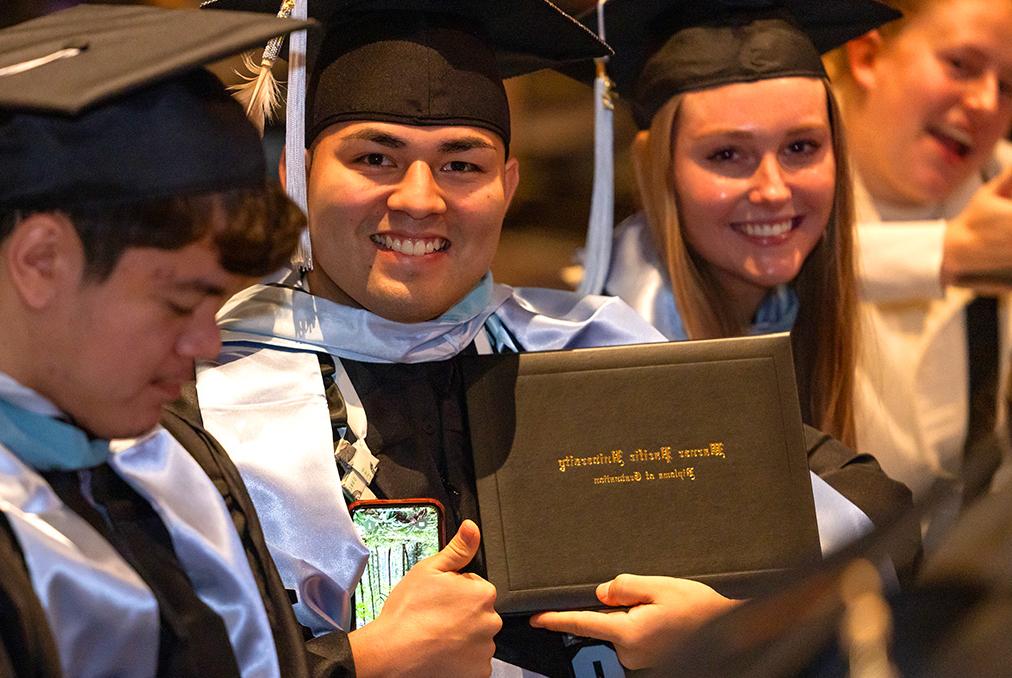 Group of graduates smile with diploma